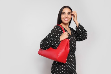 Young woman with stylish bag on white background,