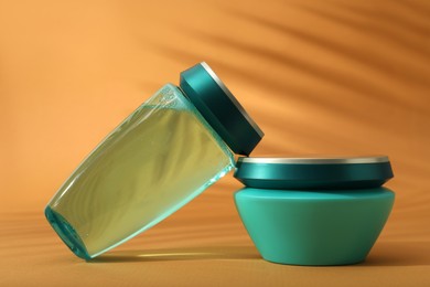 Photo of Hair care cosmetic products on orange background