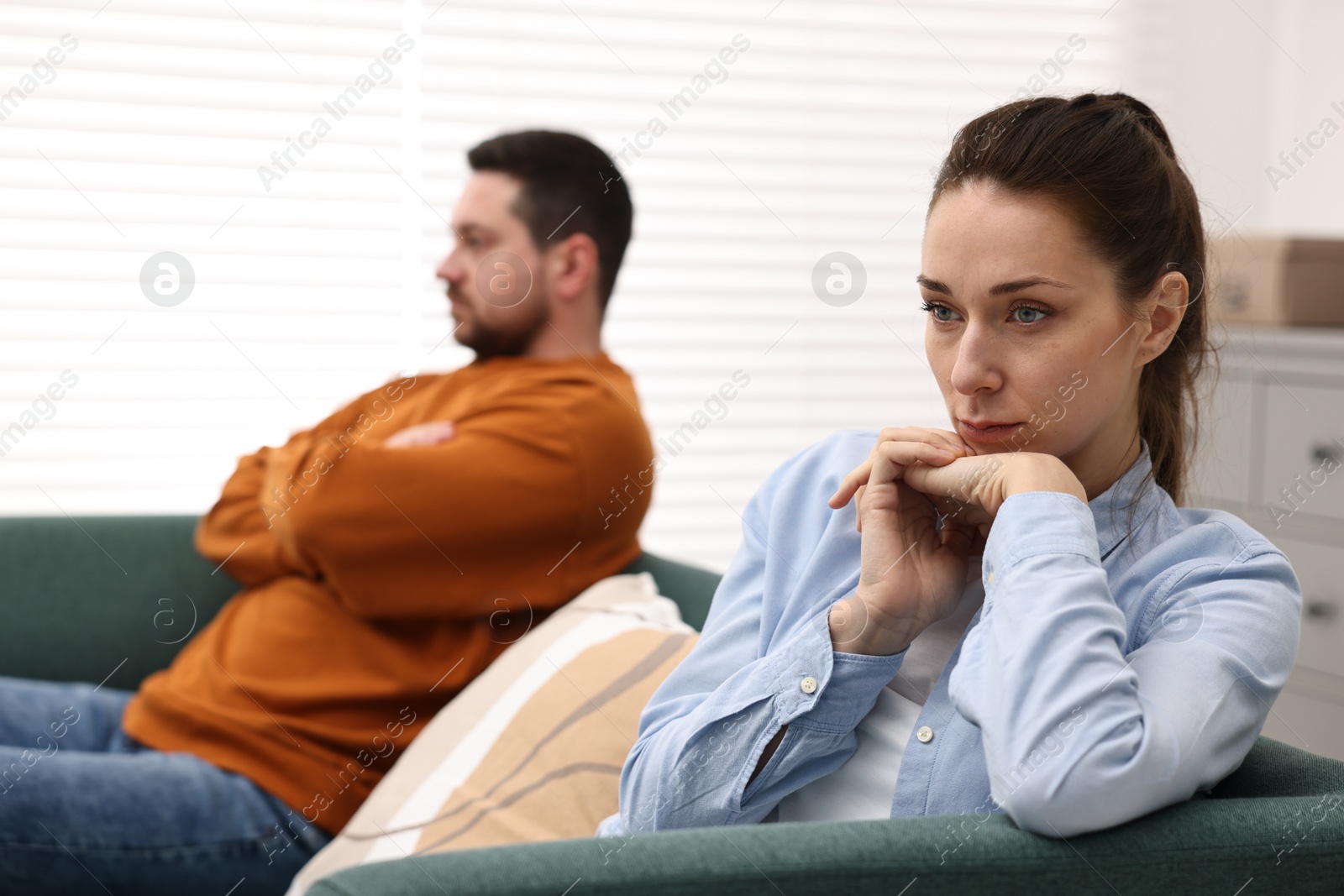 Photo of Offended couple ignoring each other after quarrel indoors, selective focus. Relationship problems