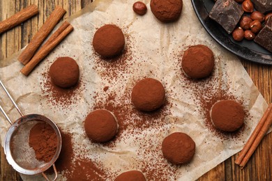 Photo of Delicious chocolate truffles and ingredients on wooden table, flat lay