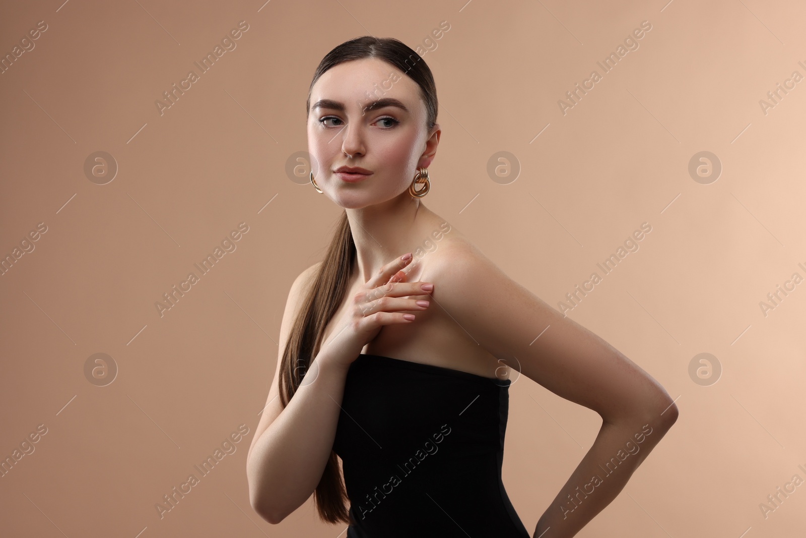 Photo of Portrait of beautiful young woman on beige background