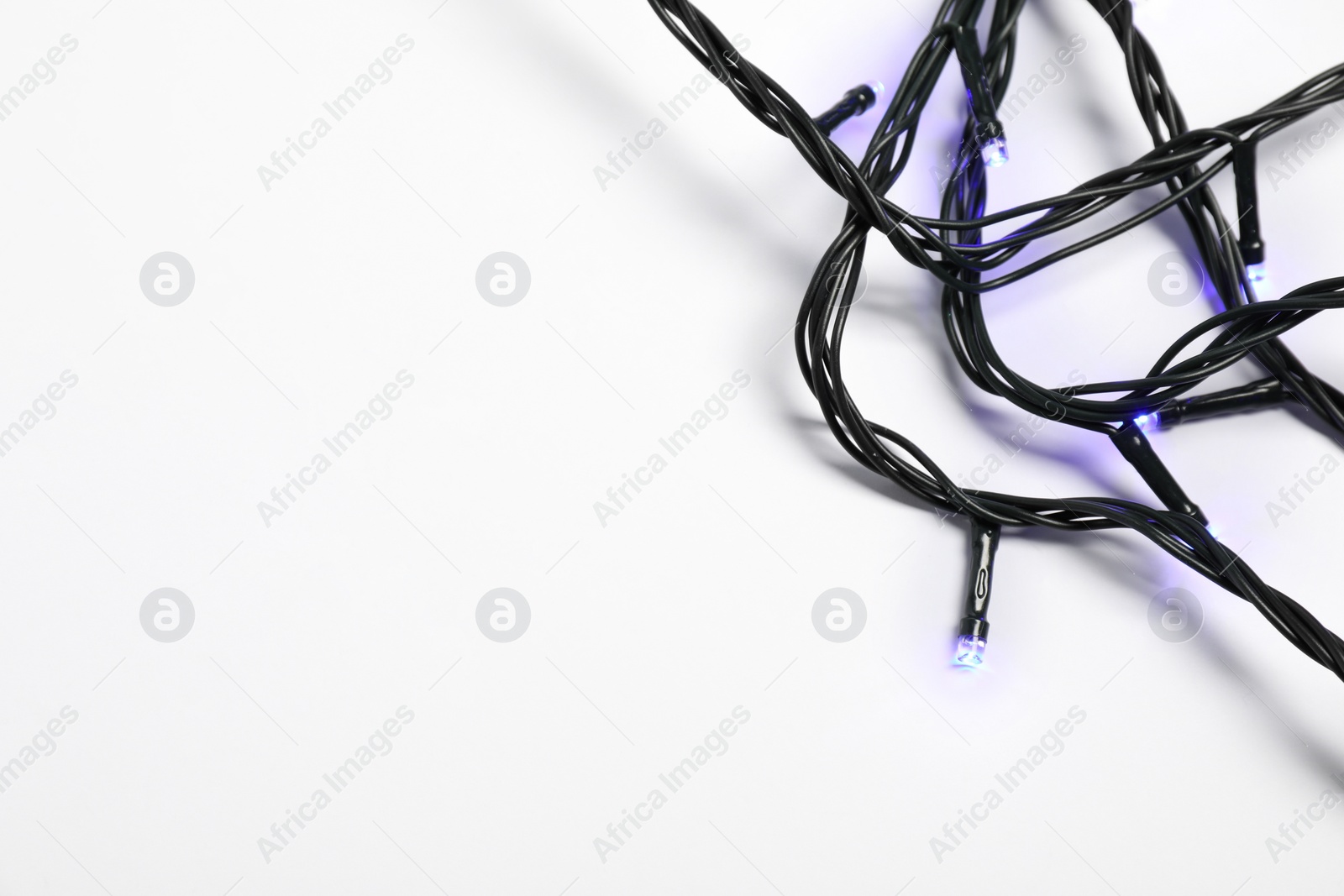 Photo of Beautiful Christmas lights on white background, top view