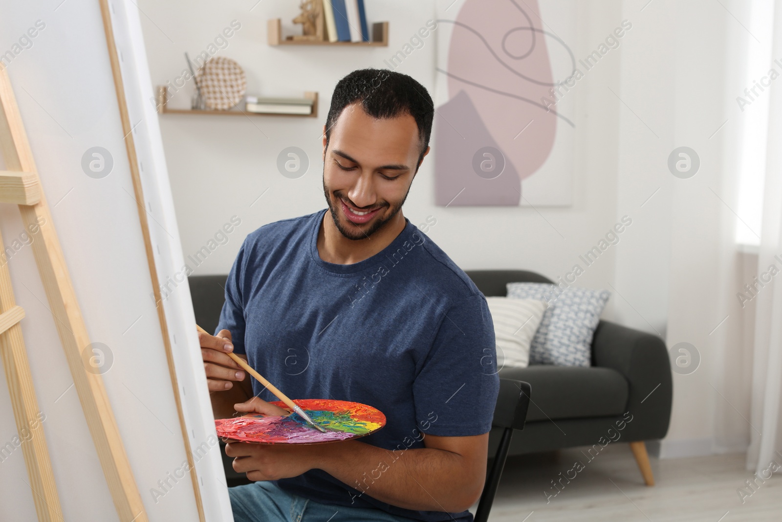 Photo of Young man painting in studio. Creative hobby