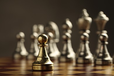 Chessboard with game pieces on grey background, closeup. Space for text
