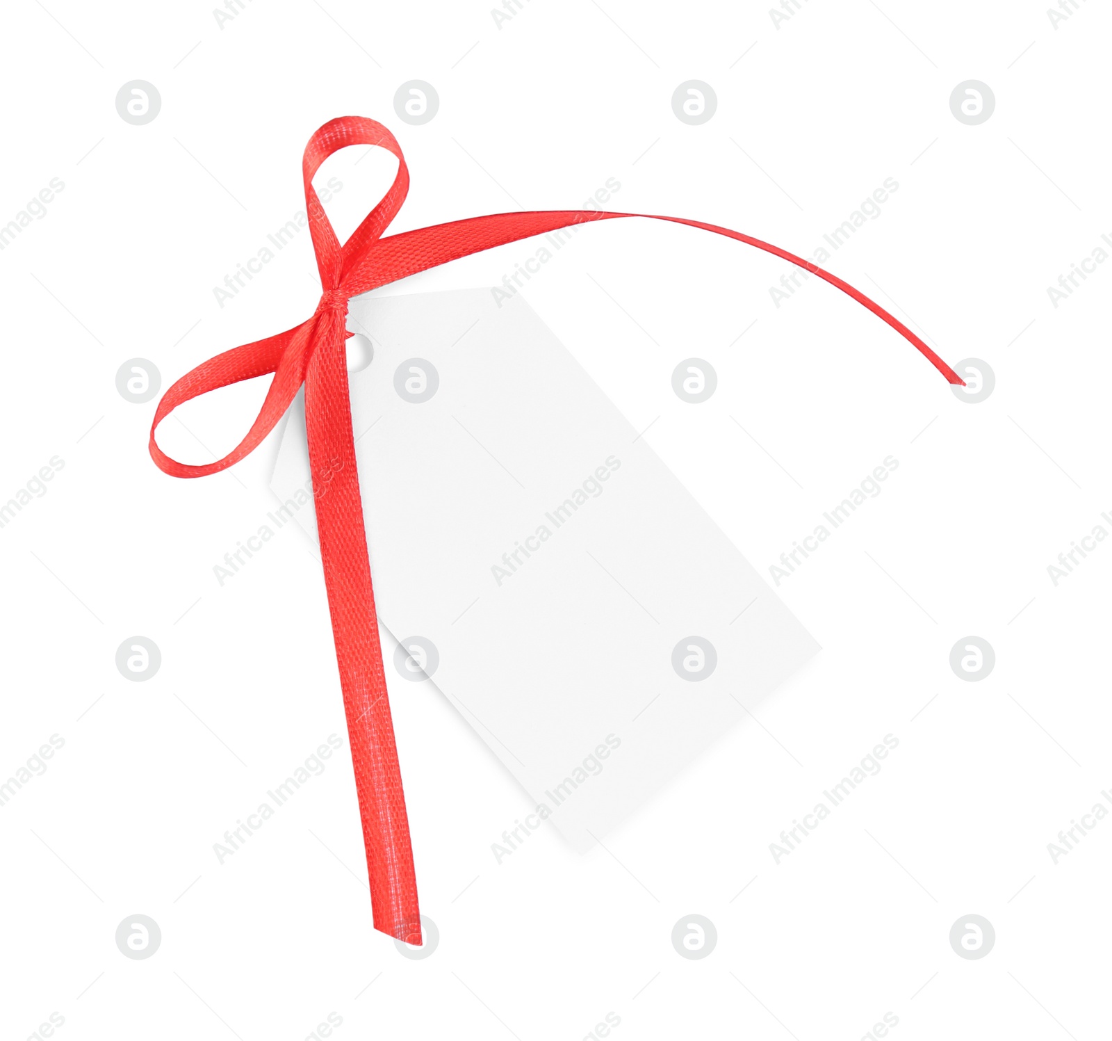 Photo of Blank gift tag with red satin ribbon on white background, top view