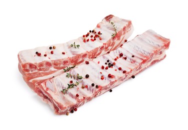 Raw pork ribs with thyme and peppercorns isolated on white