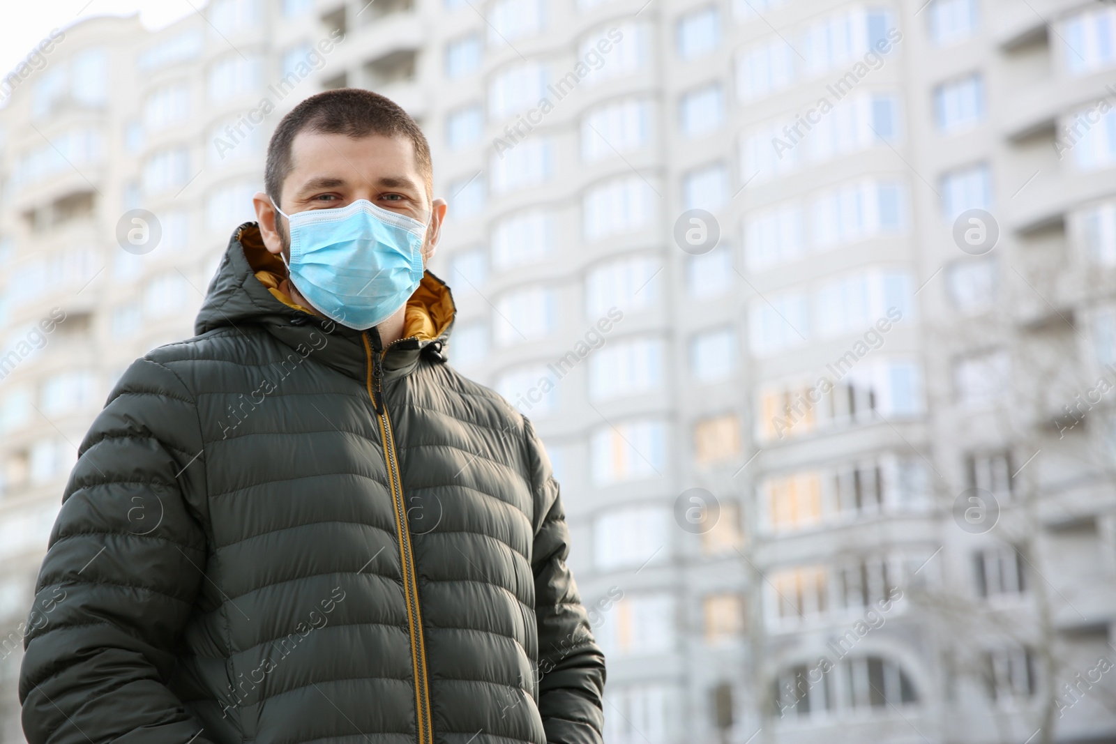 Photo of Man wearing disposable mask outdoors. Dangerous virus