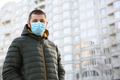 Photo of Man wearing disposable mask outdoors. Dangerous virus