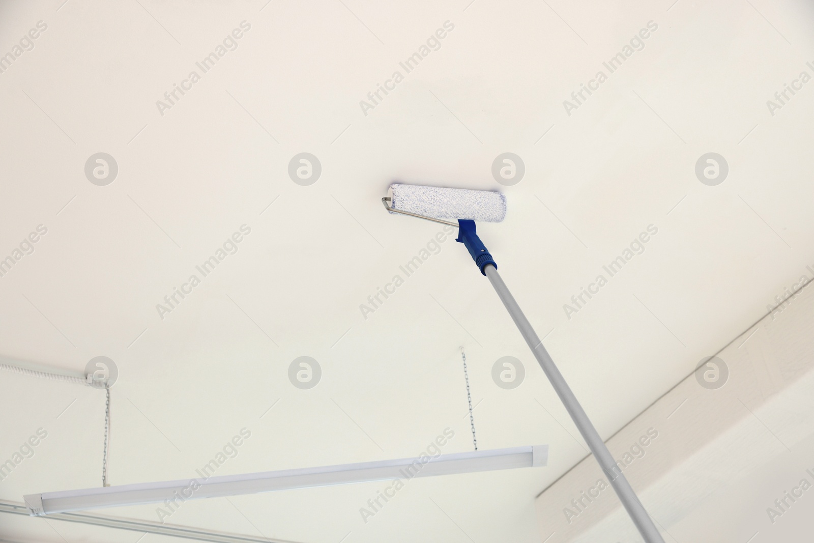 Photo of Painting ceiling with white dye indoors, low angle view