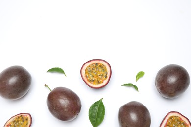 Photo of Fresh ripe passion fruits (maracuyas) with leaves on white background, flat lay. Space for text