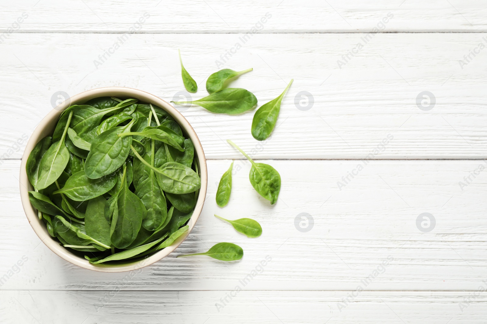 Photo of Fresh green healthy spinach on white wooden table, flat lay. Space for text