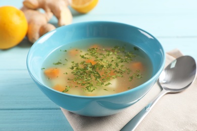 Bowl of fresh homemade soup to cure flu on wooden table