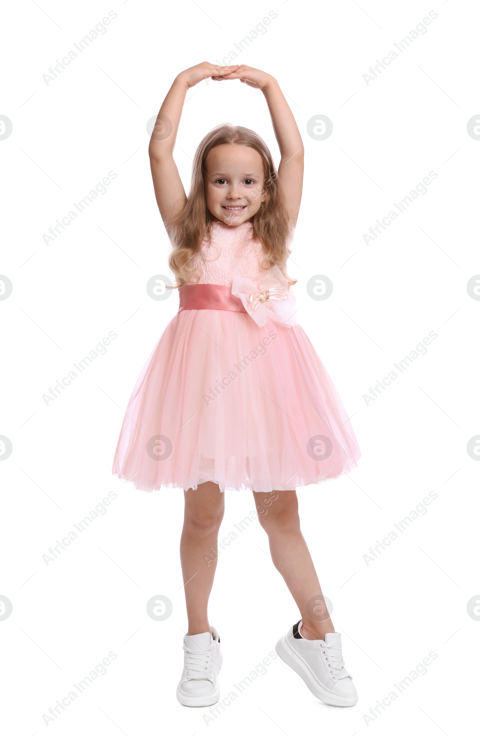 Photo of Cute little girl in beautiful dress dancing on white background