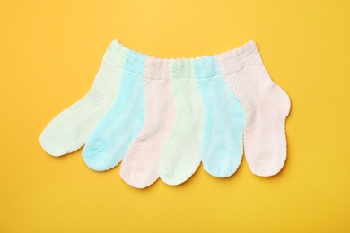 Photo of Cute child socks on color background, flat lay