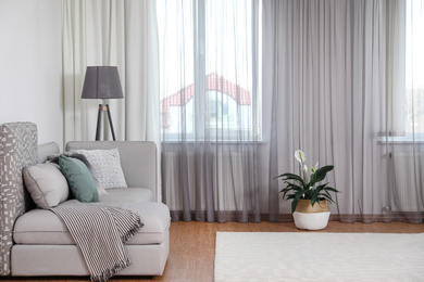 Window with stylish curtains in living room interior