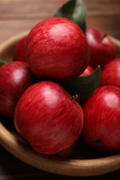 Photo of Ripe red apples in wooden bowl on table, closeup