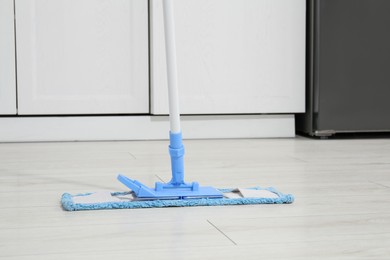 Photo of Cleaning of parquet floor with mop indoors