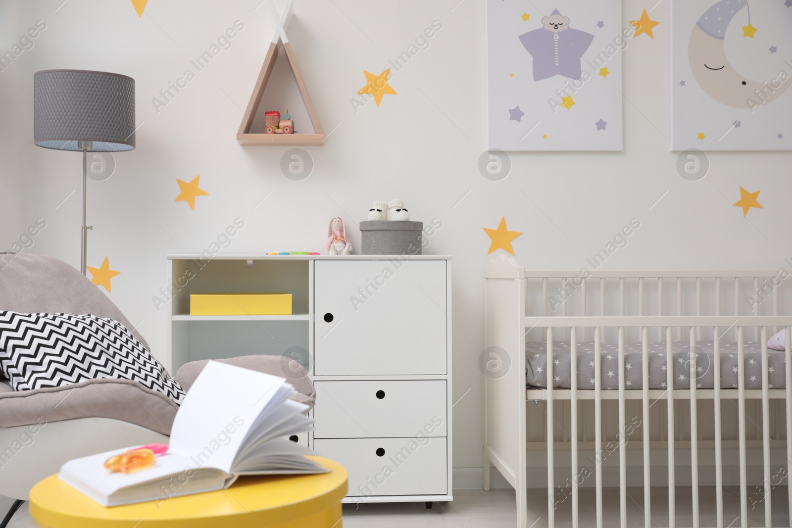 Photo of Stylish baby room interior with crib and decor elements