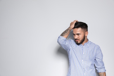 Portrait of handsome young man against light background. Space for text