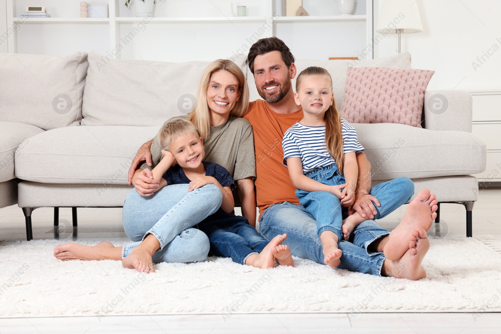 Photo of Portrait of happy family with children on soft rug at home