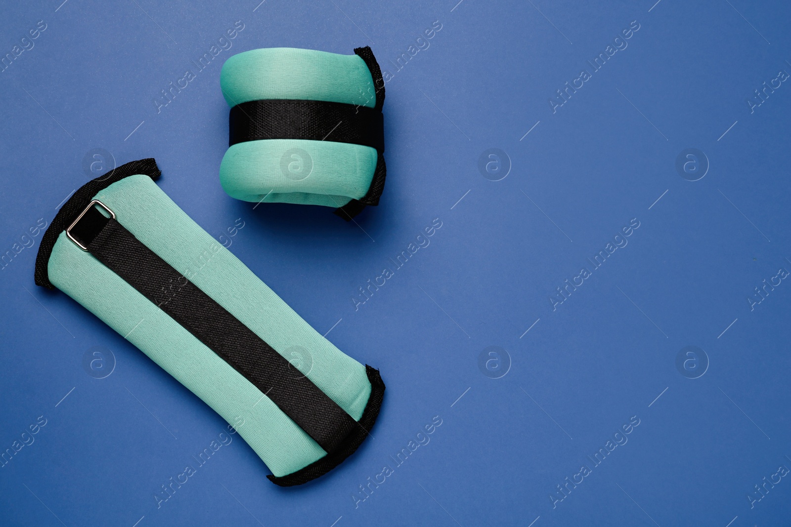 Photo of Turquoise weighting agents on blue background, flat lay. Space for text