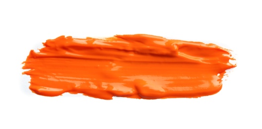 Photo of Abstract brushstroke of orange paint isolated on white