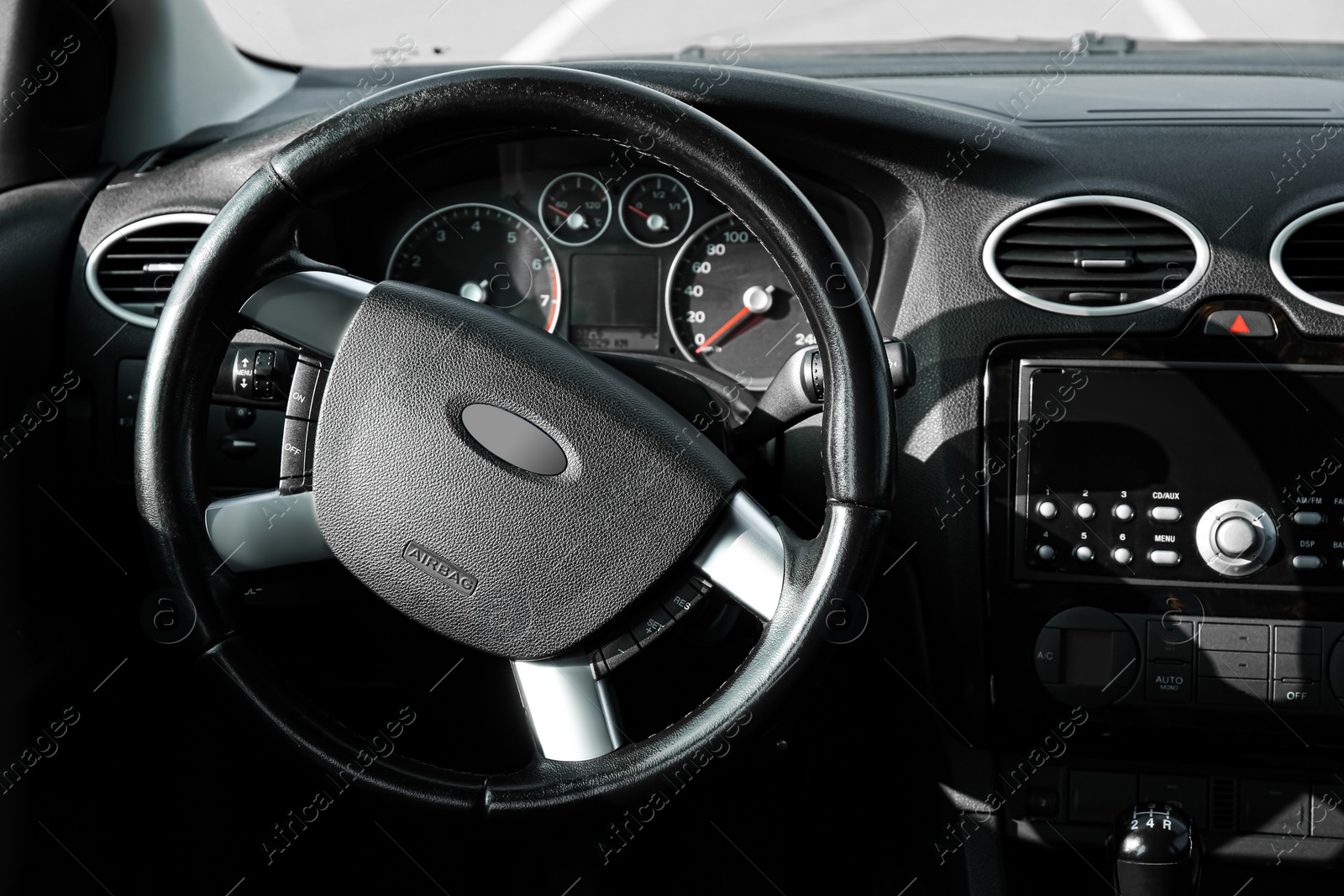 Photo of Black steering wheel and dashboard in car