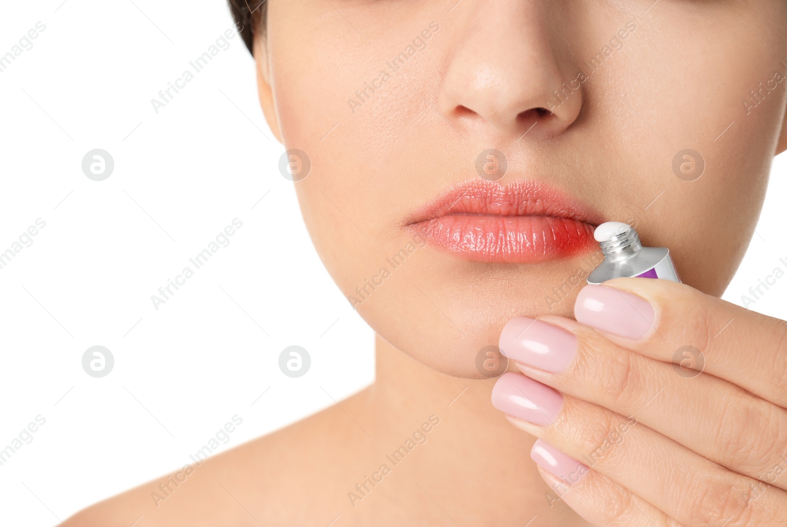 Photo of Woman applying cream onto lips on white background, closeup