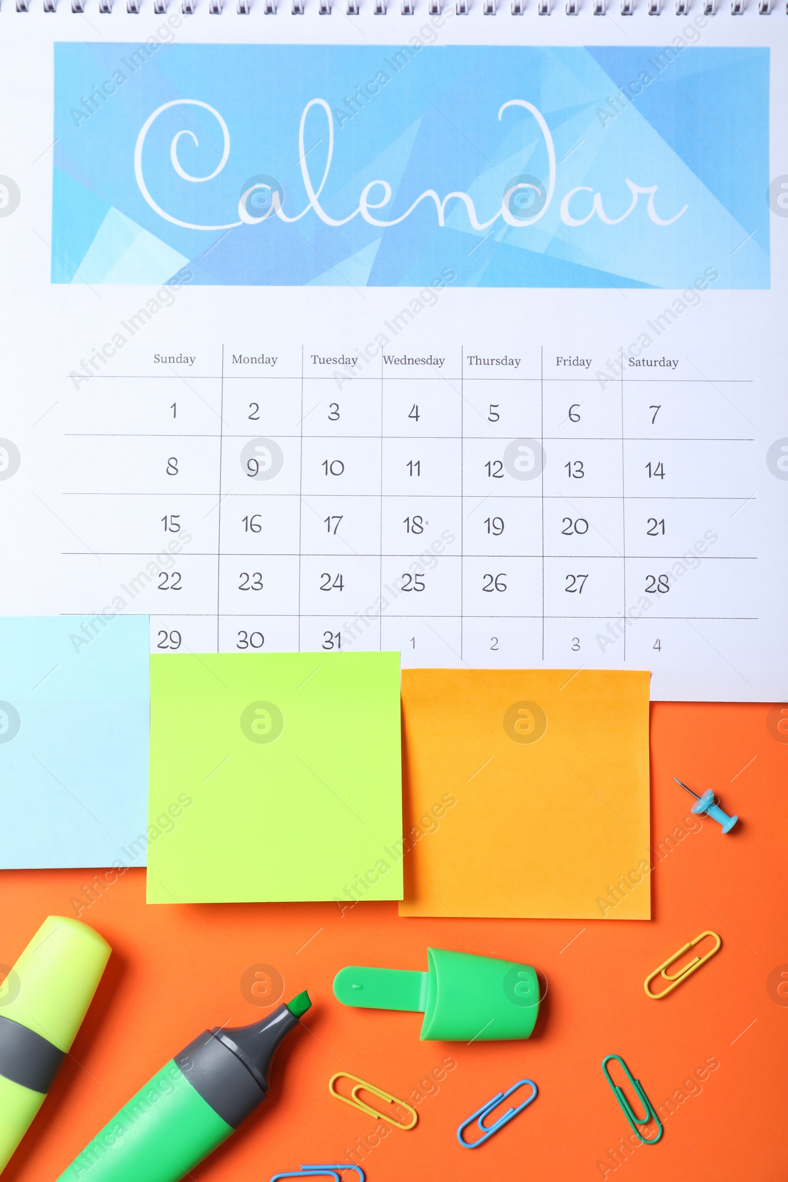 Photo of Calendar page and office stationery on orange background, flat lay