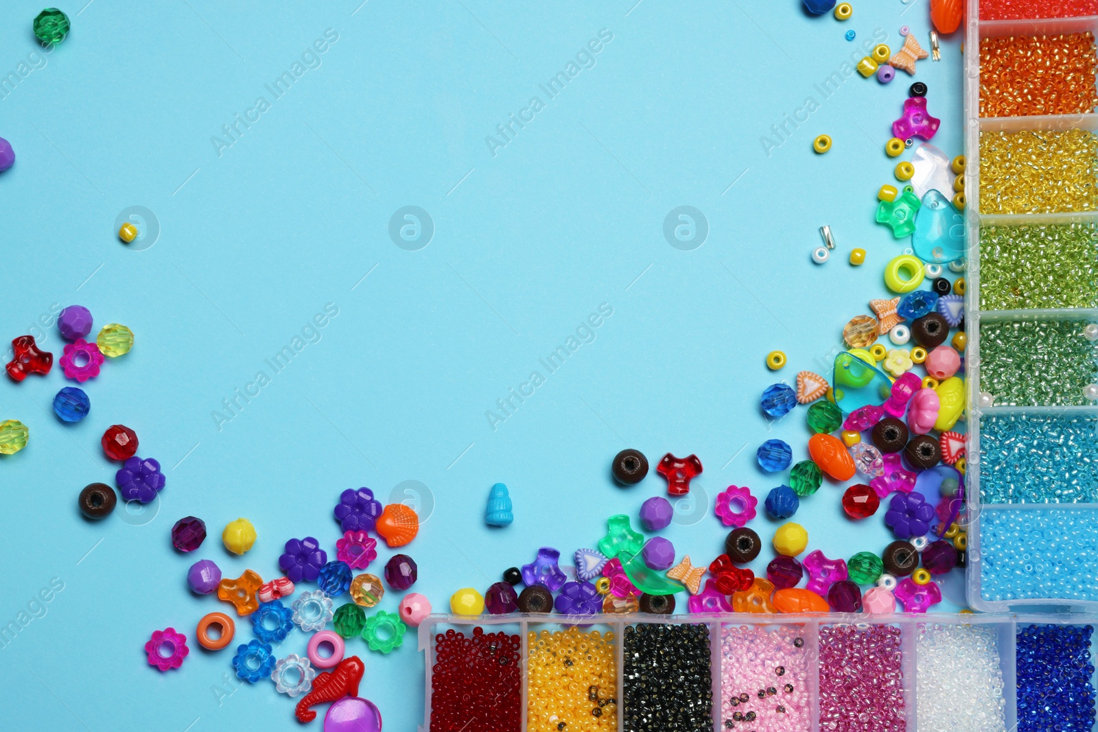 Photo of Flat lay composition with different colorful beads on light blue background, space for text