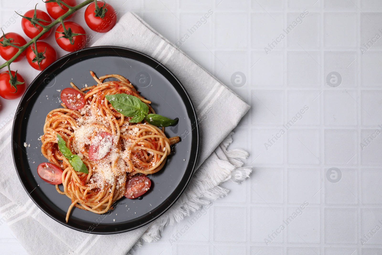 Photo of Tasty pasta with tomato sauce, cheese and basil on white tiled table, flat lay. Space for text