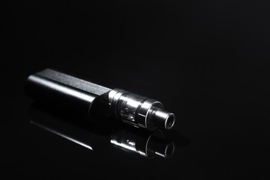 Electronic cigarette on black background, space for text