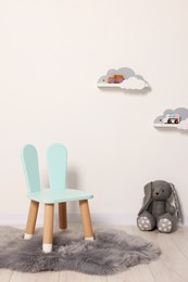 Beautiful children's room with light wall, chair and toys. Interior design