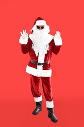 Full length portrait of Santa Claus with sunglasses on red background