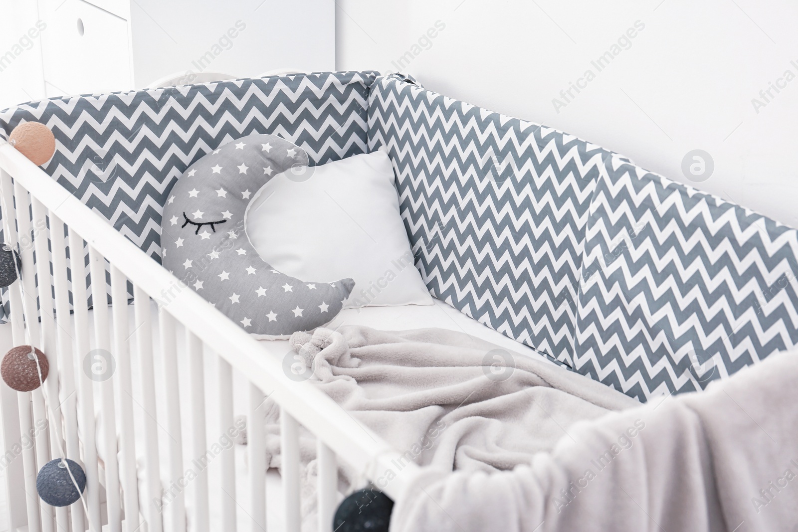 Photo of Comfortable crib in baby room. Idea for interior design