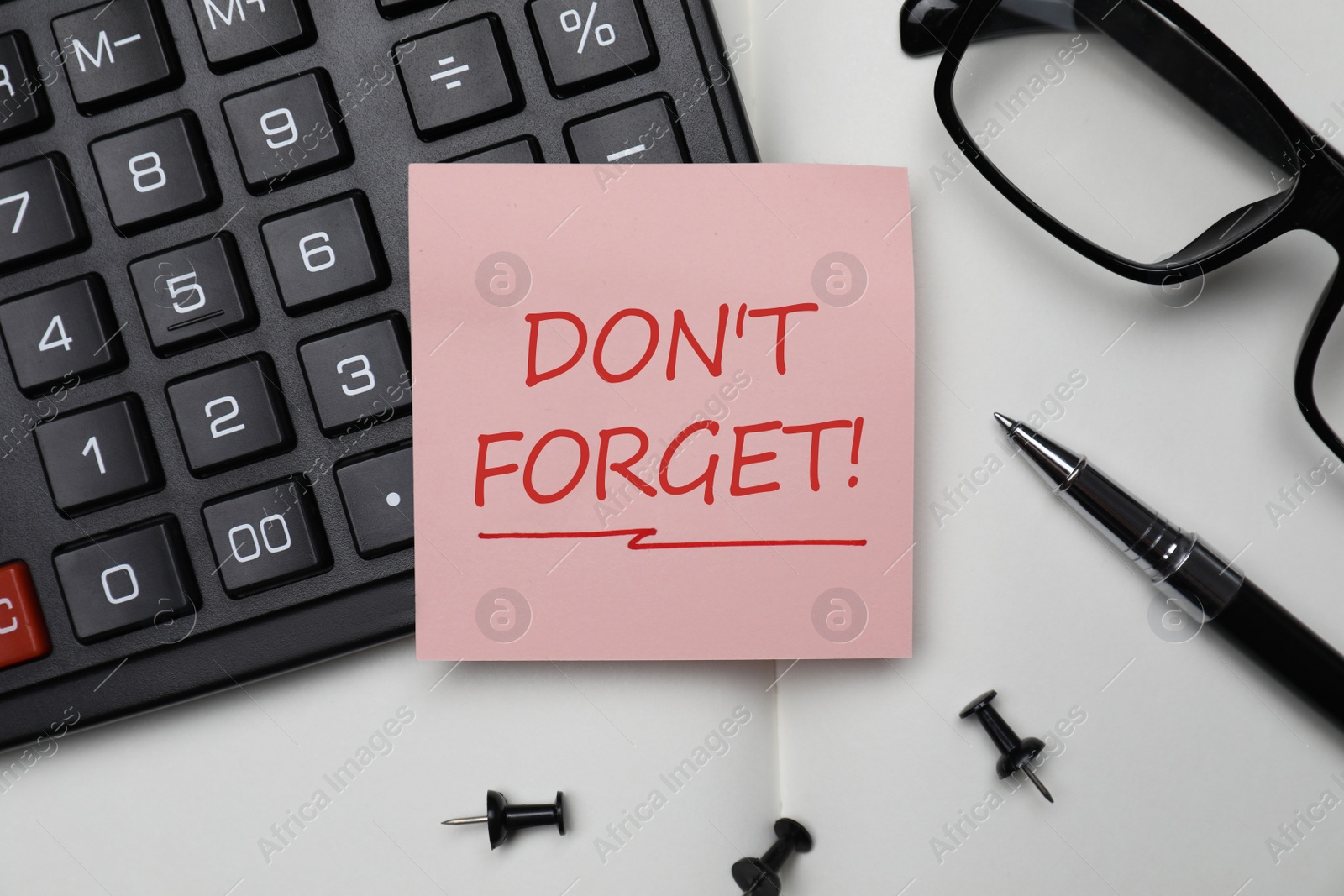 Image of Reminder note with text DON'T FORGET, calculator and pen on open notebook, flat lay 