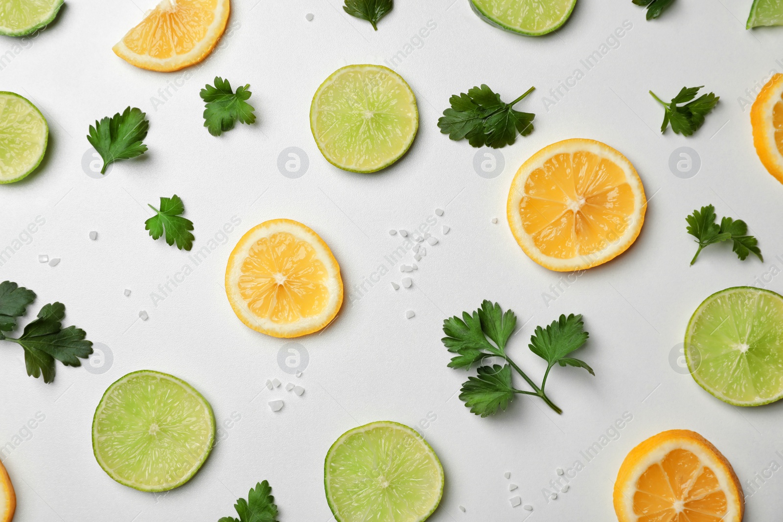 Photo of Flat lay composition with green parsley, salt and citrus fruits on light background