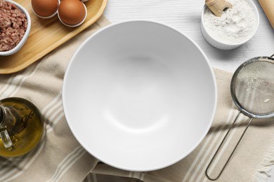Photo of Bowl and different products on white wooden table, flat lay