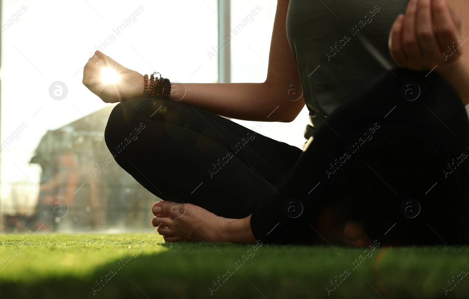 Photo of Young woman practicing yoga in sunlit room, closeup