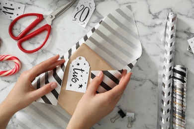 Photo of Woman making advent calendar at white marble table, top view