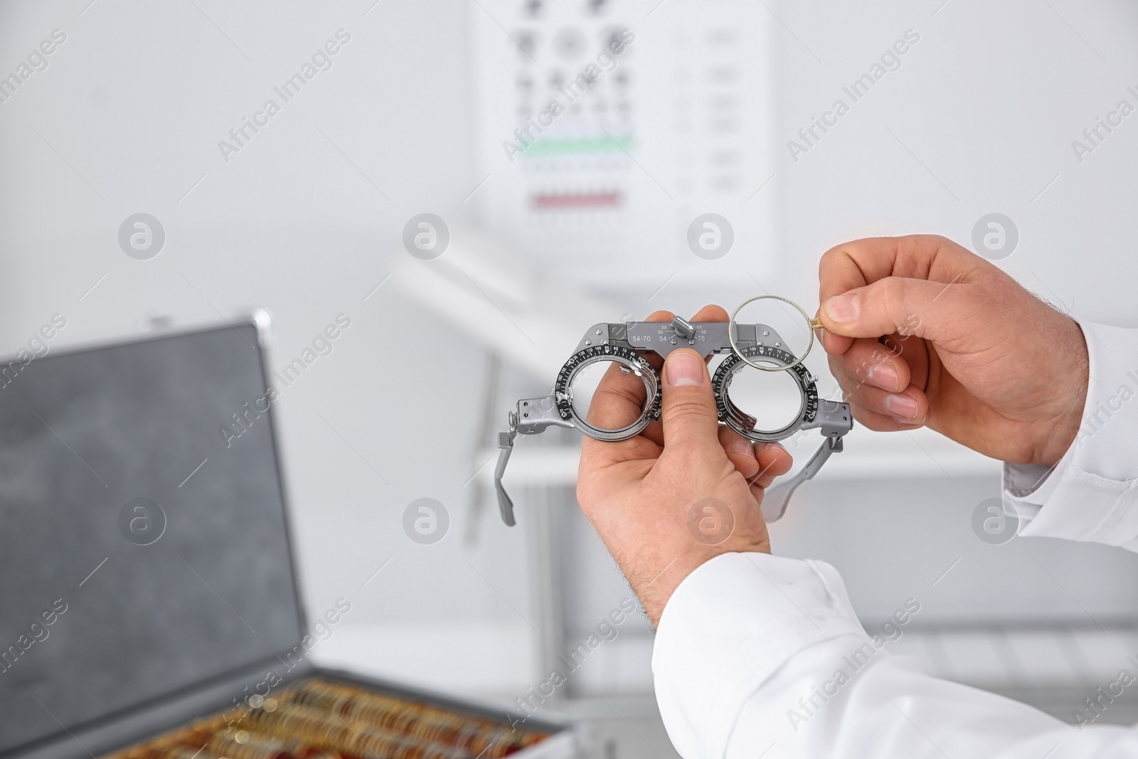 Photo of Children doctor holding trial frame and lens on blurred background