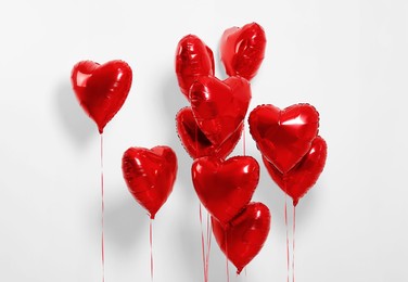 Many red heart shaped balloons on white background