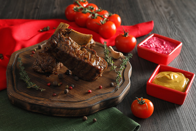 Photo of Delicious roasted ribs served on wooden table