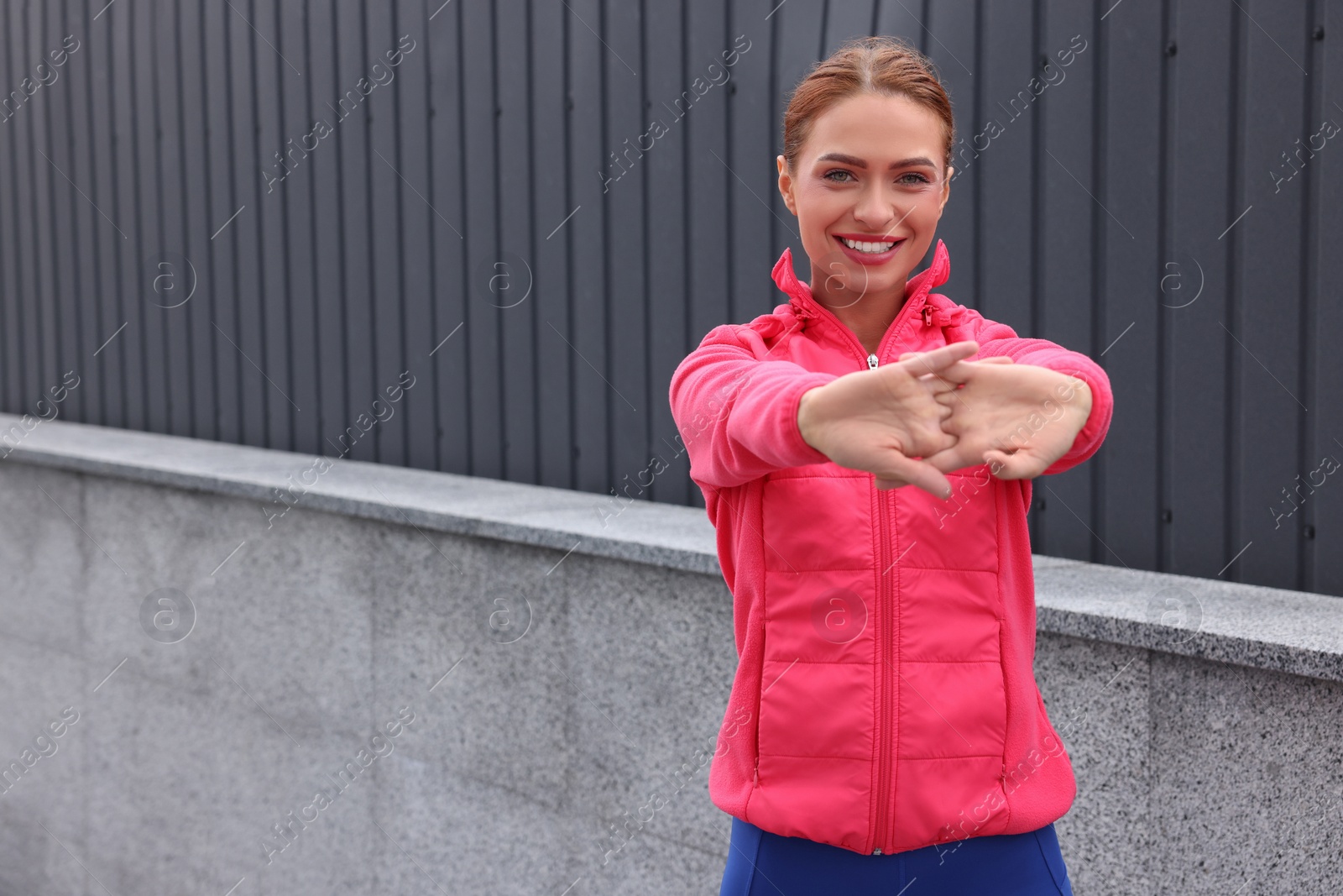 Photo of Beautiful woman in gym clothes doing exercises on street, space for text