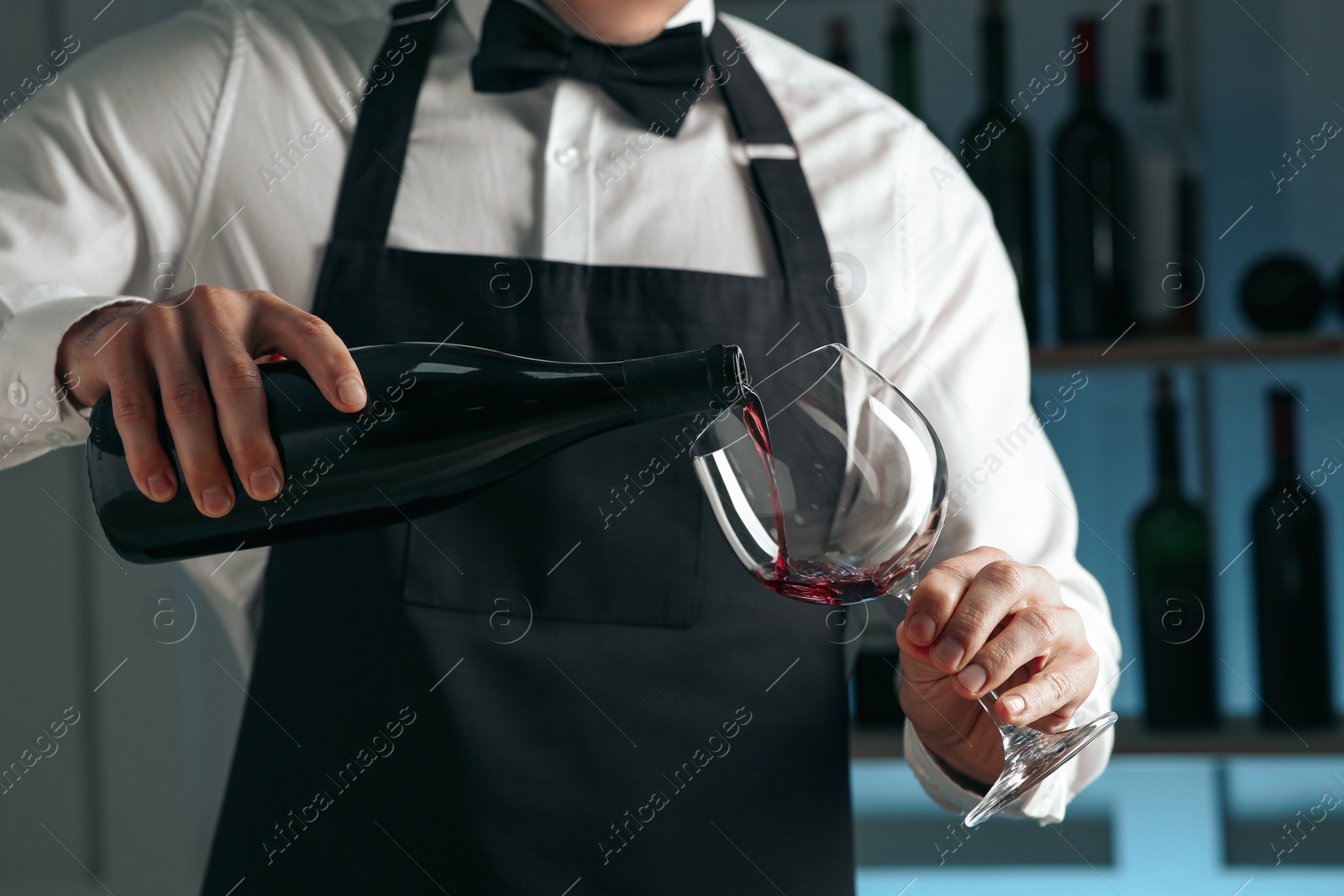 Photo of Bartender pouring wine into glass in restaurant, closeup