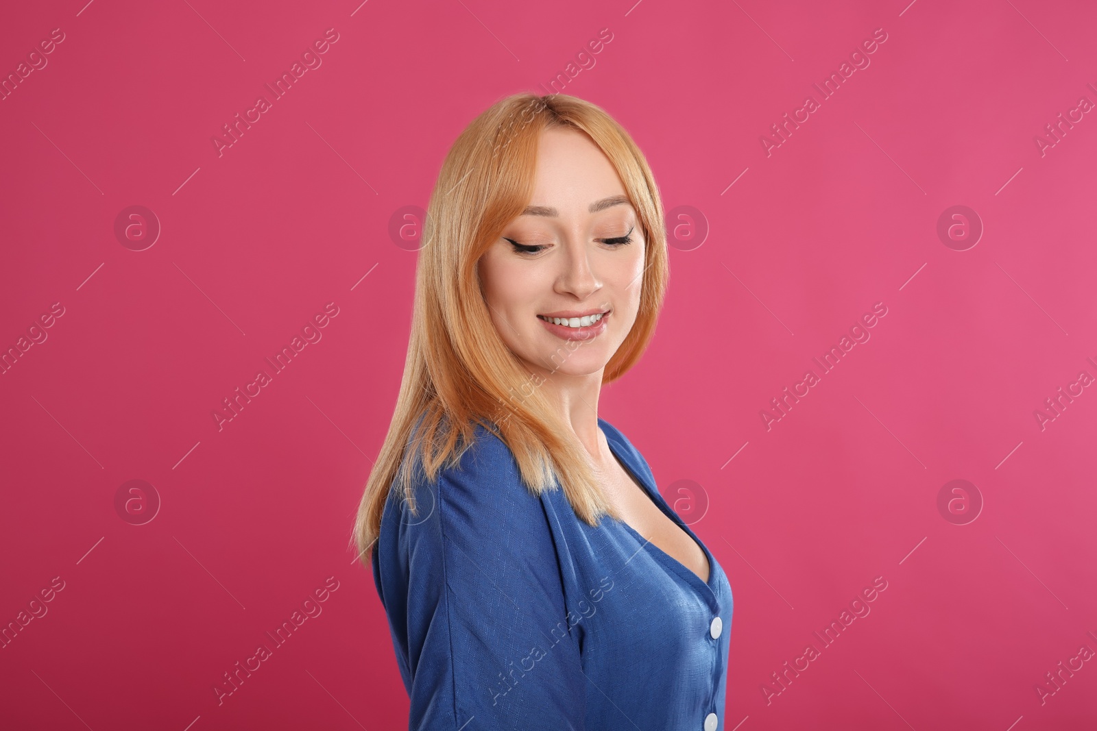 Photo of Beautiful young woman with blonde hair on pink background