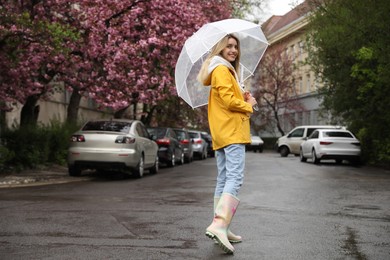 Photo of Young woman with umbrella walking on spring day