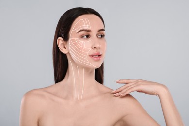 Attractive woman with perfect skin after cosmetic treatment on grey background. Lifting arrows on her face
