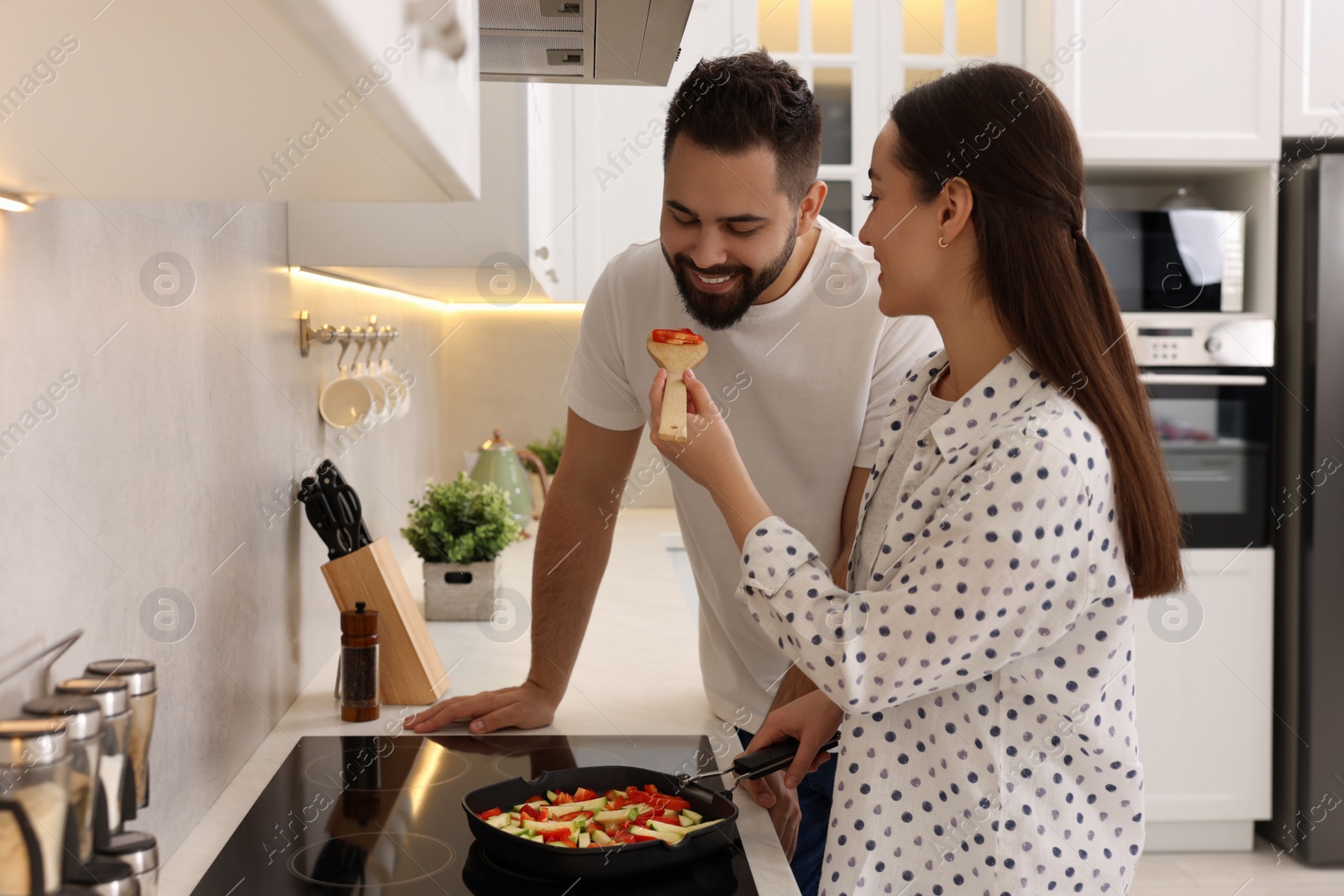 Photo of Happy lovely couple cooking together in kitchen