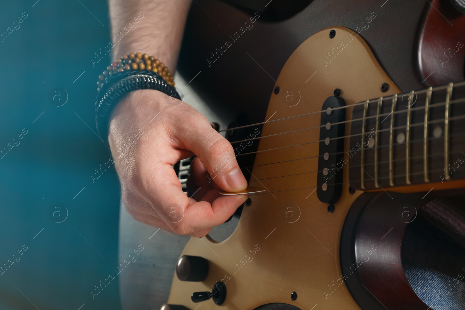 Photo of Man playing electric guitar on stage, closeup. Rock concert